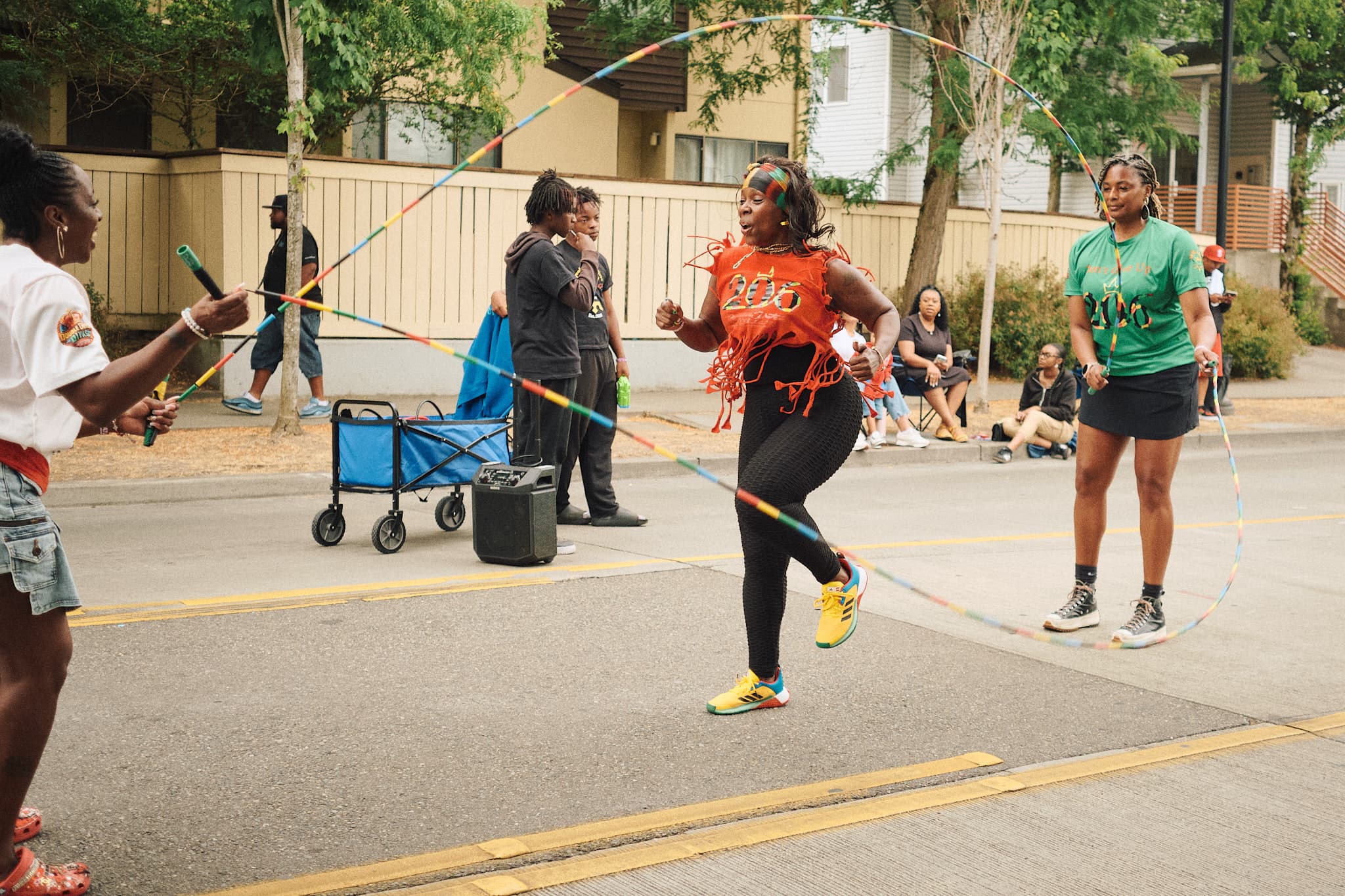 Community members playing double dutch in the street.